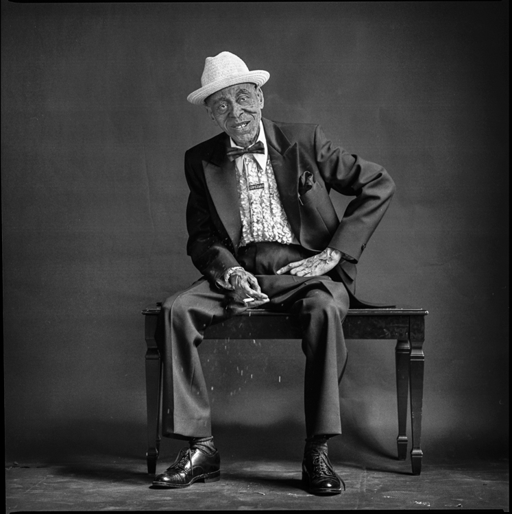 Tuts Washington sitting on piano bench